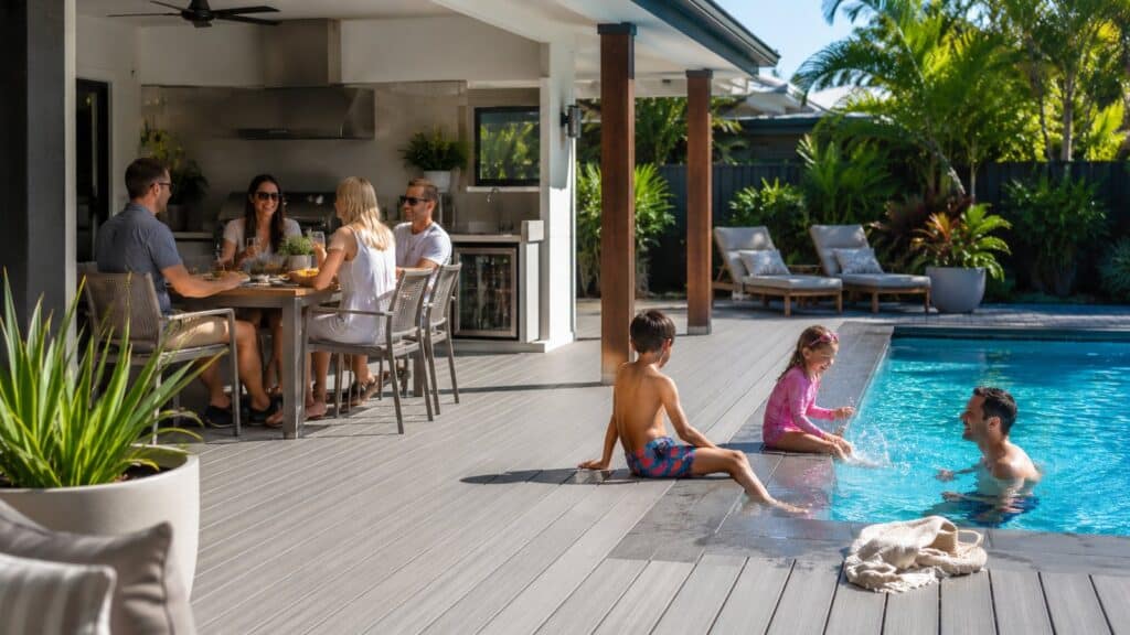 Family relaxing and entertaining around a poolside deck with outdoor dining and seating.