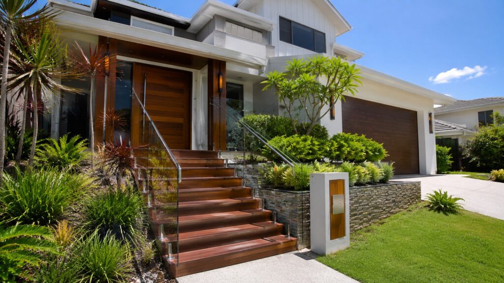Modern two-storey home in Pimpama featuring a custom hardwood front staircase with glass balustrade.