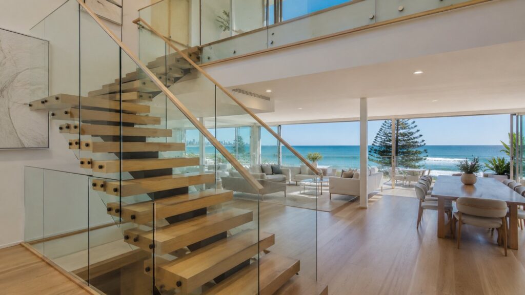 Modern Main Beach home featuring a floating timber staircase with glass balustrade overlooking the ocean.