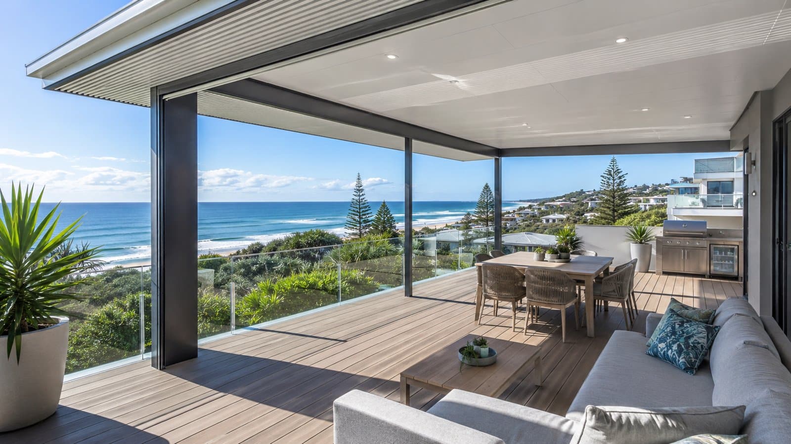 Modern coastal patio featuring aluminium framing, insulated roofing, and composite decking under bright Queensland sunshine.