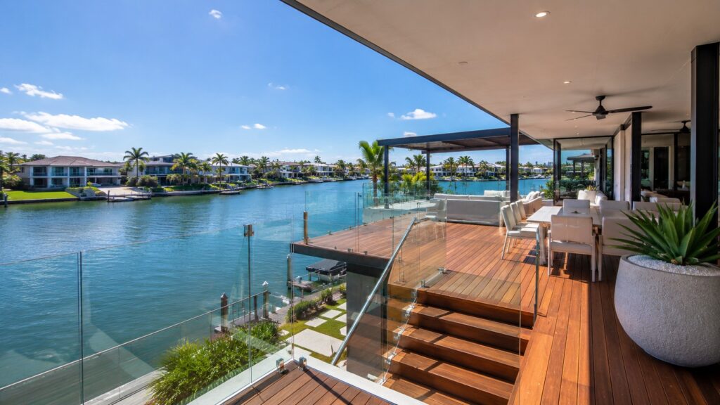 Frameless glass balustrade providing uninterrupted canal views from a luxury outdoor deck.