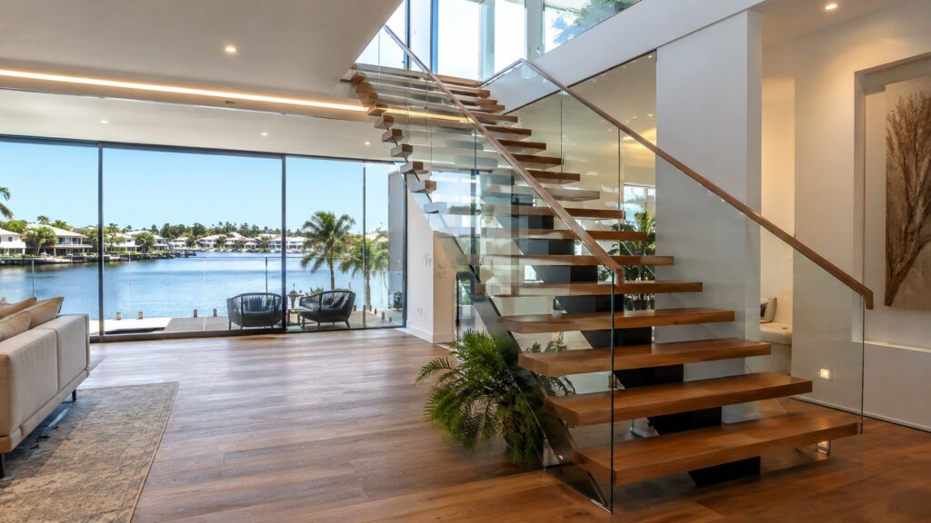 Modern floating staircase with glass balustrade in a luxury Benowa riverfront home.