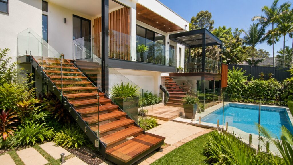 Multi-level outdoor hardwood staircase connecting a home's entrance, pool area and garden.