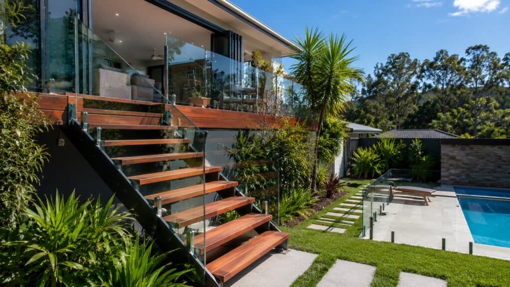 Stairs Upper Coomera 2 Custom outdoor timber staircase connecting an elevated deck to a landscaped backyard and pool.