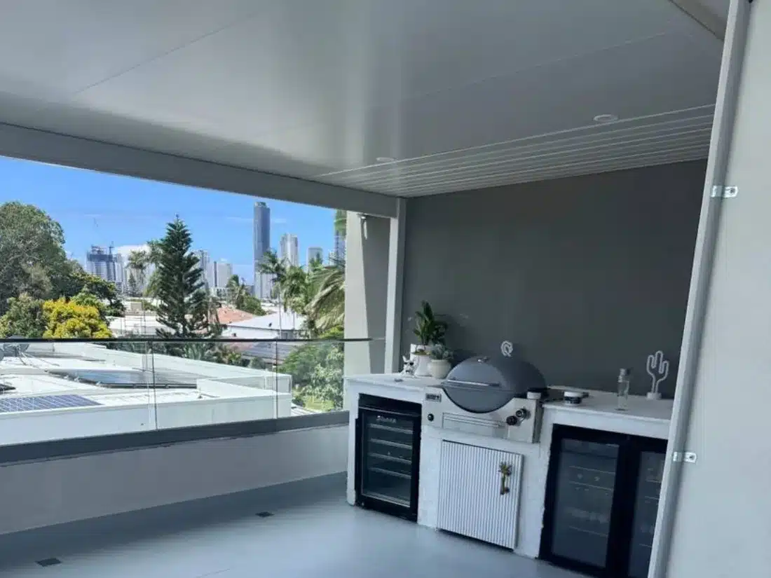 Insulated roof over an upper level tiled entertaining area with built-in BBQ and city views